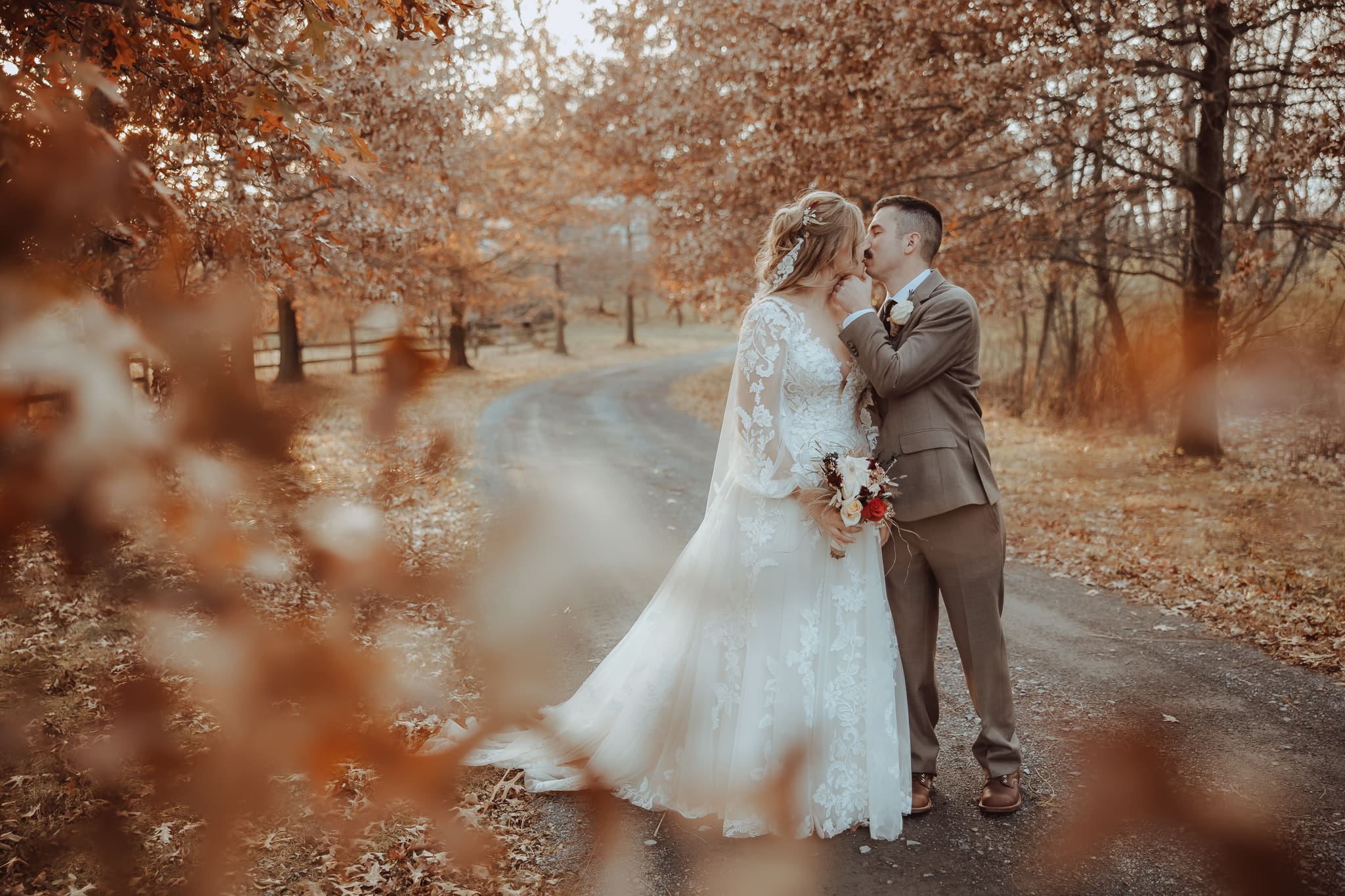 Couple kissing in fall foliage at Foxglove farm wedding venue in Oley PA.