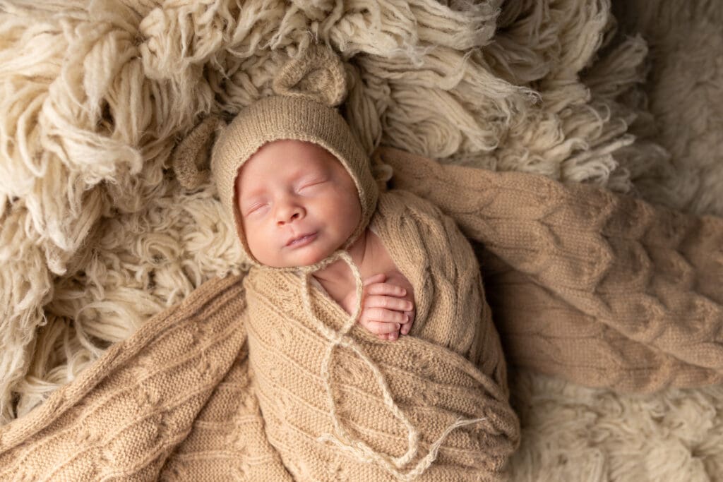 Newborn with teddy bear ears wrapped in brown swaddle for Lehigh valley newborn photography session.