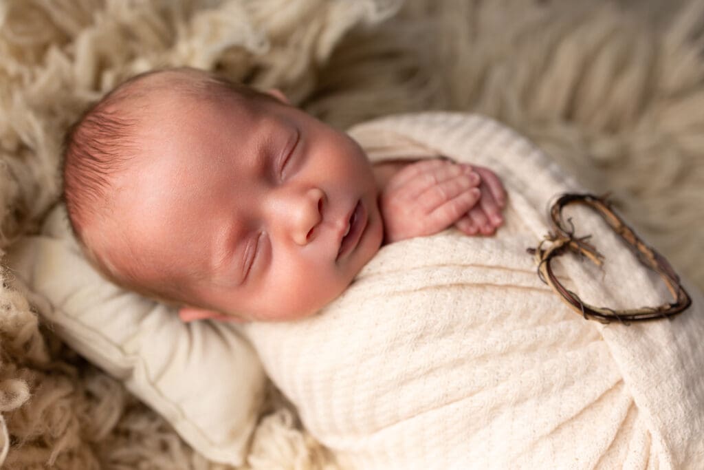 Newborn baby holds heart for Lehigh valley newborn photography session in coopersburg pa.