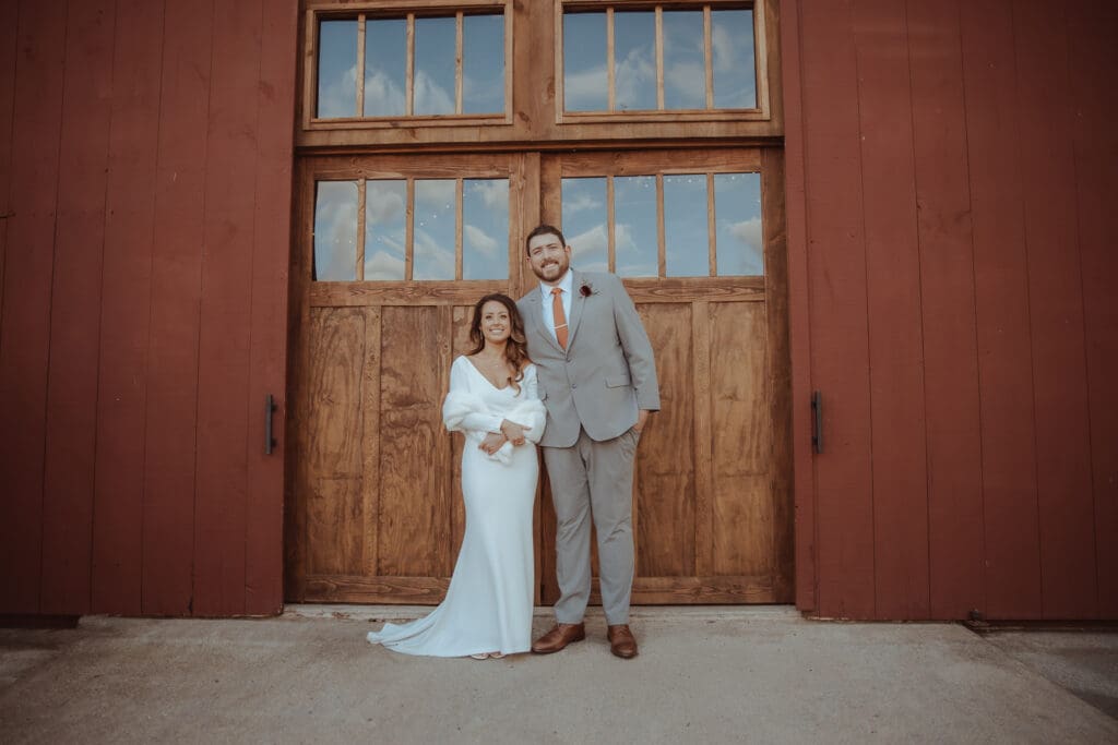 Bride and Groom standing in front of the barn for thier Maple Valley farm wedding in Barto PA. 