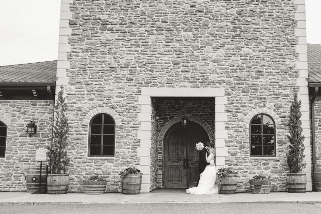 Bride and groom pose at the entrance of Folino eststae winery in Berks County PA.
