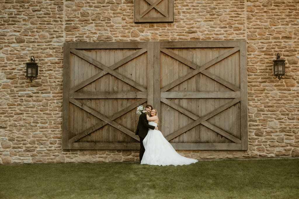 Folino Estate Winery barn doors hold onto bride and groom during their portraits in Berks County PA.