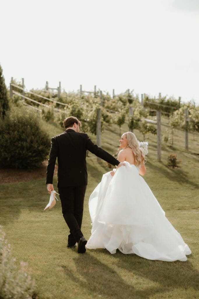 Bride and groom walk into the vineyard of Folino Estate winery in Kutztown PA.