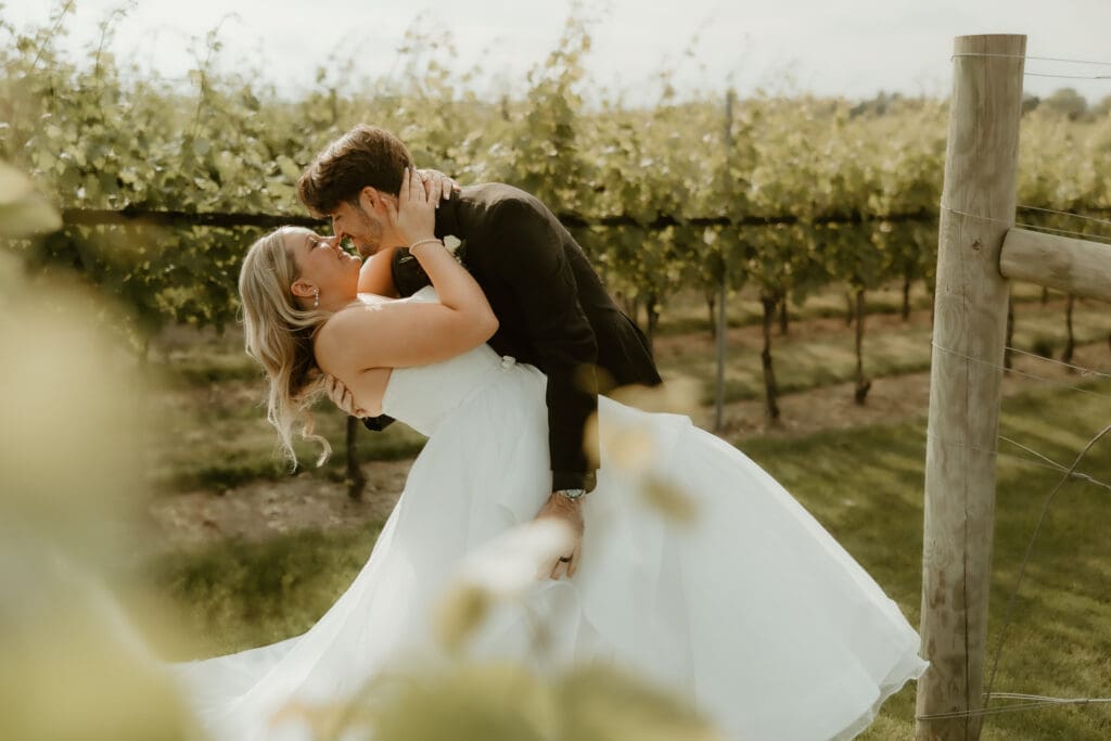 Bride and groom kiss in the middle of the vineyard of Folino Estate winery in Berks County PA.