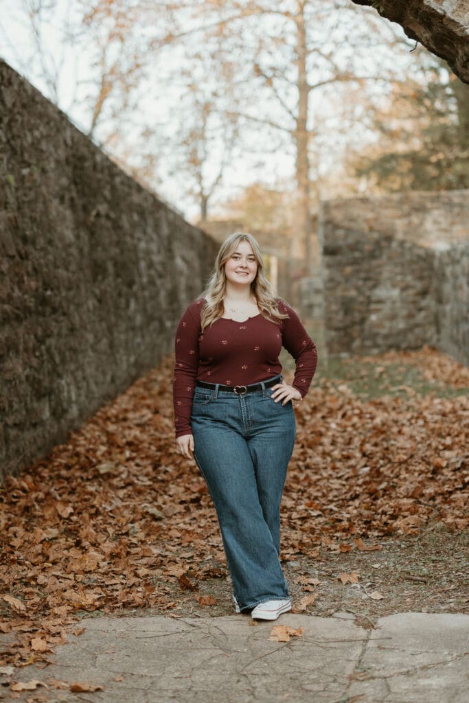 Senior girl posing in fall leaves for her 2026 senior photo session in Lehigh Valley PA. 