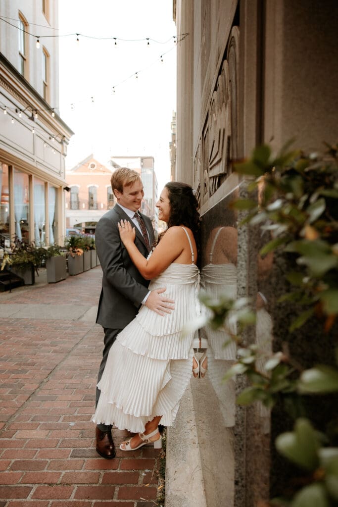 Couple share romatic embrace between buildings in downtown Easton. 