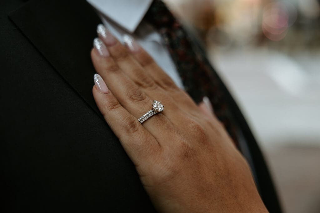 Ring shot featuring sparkly bridal nails and a 2 carrot engagement ring. 